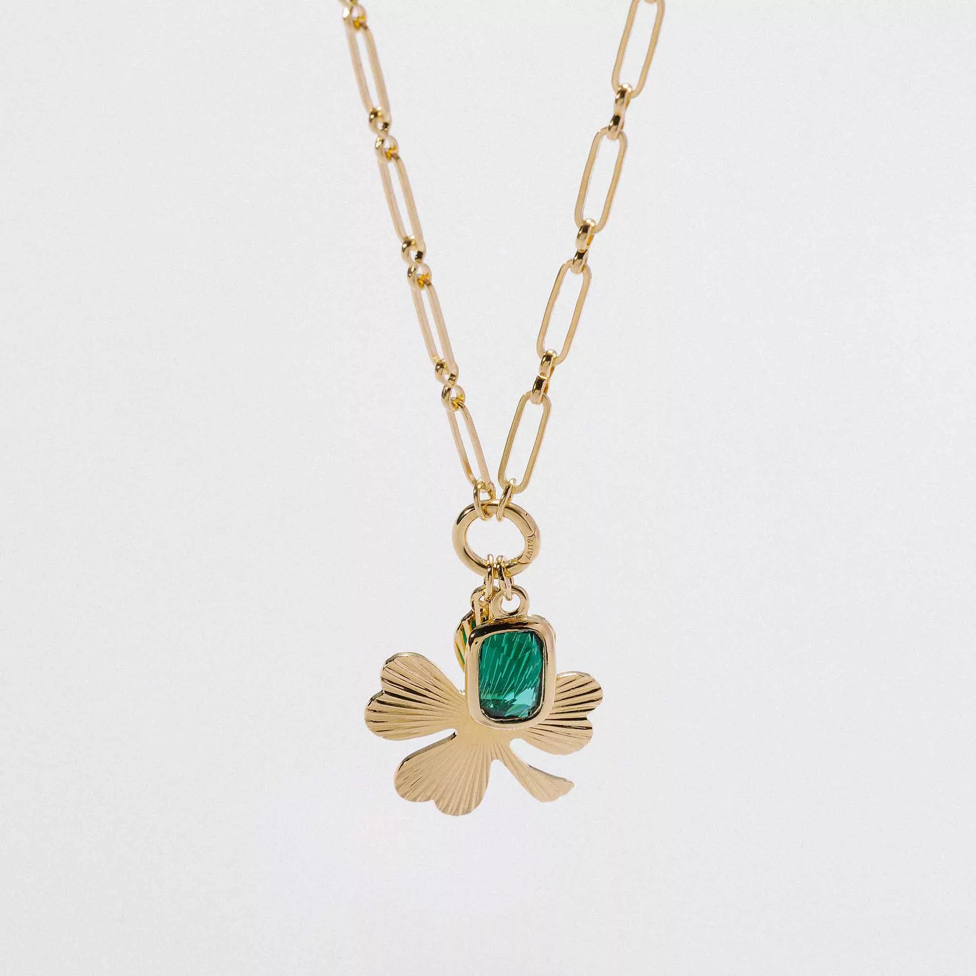 &LIVY Good Things Grow Expandable Necklace gold close-up detail of Shine On Clover charm with emerald crystal on paperclip intention chain