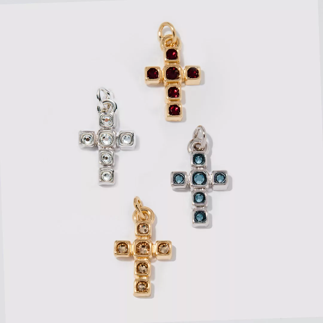 Four cross-shaped pendants in different colors on a white background