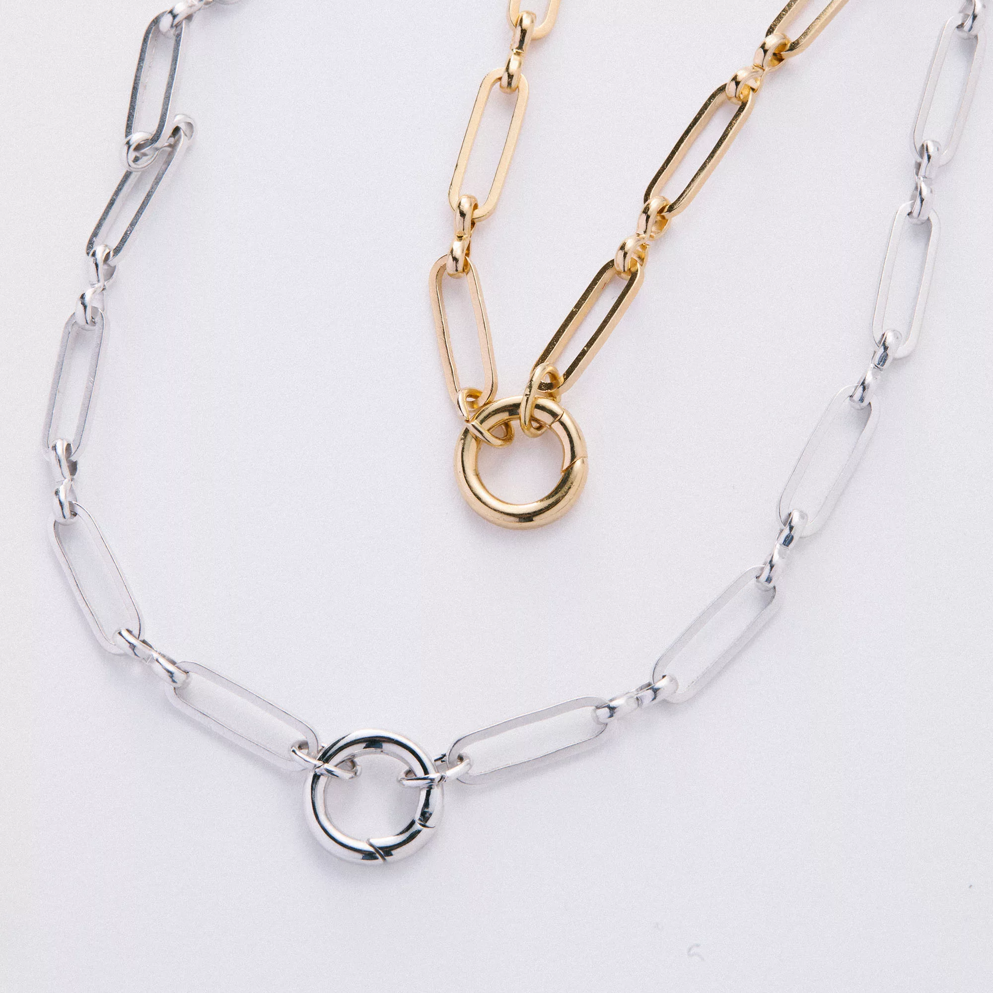 &LIVY Paperclip Intention Chain in both finely finished silver and finely finished gold layered together showing elongated paperclip links and round interlocking ring charm holders