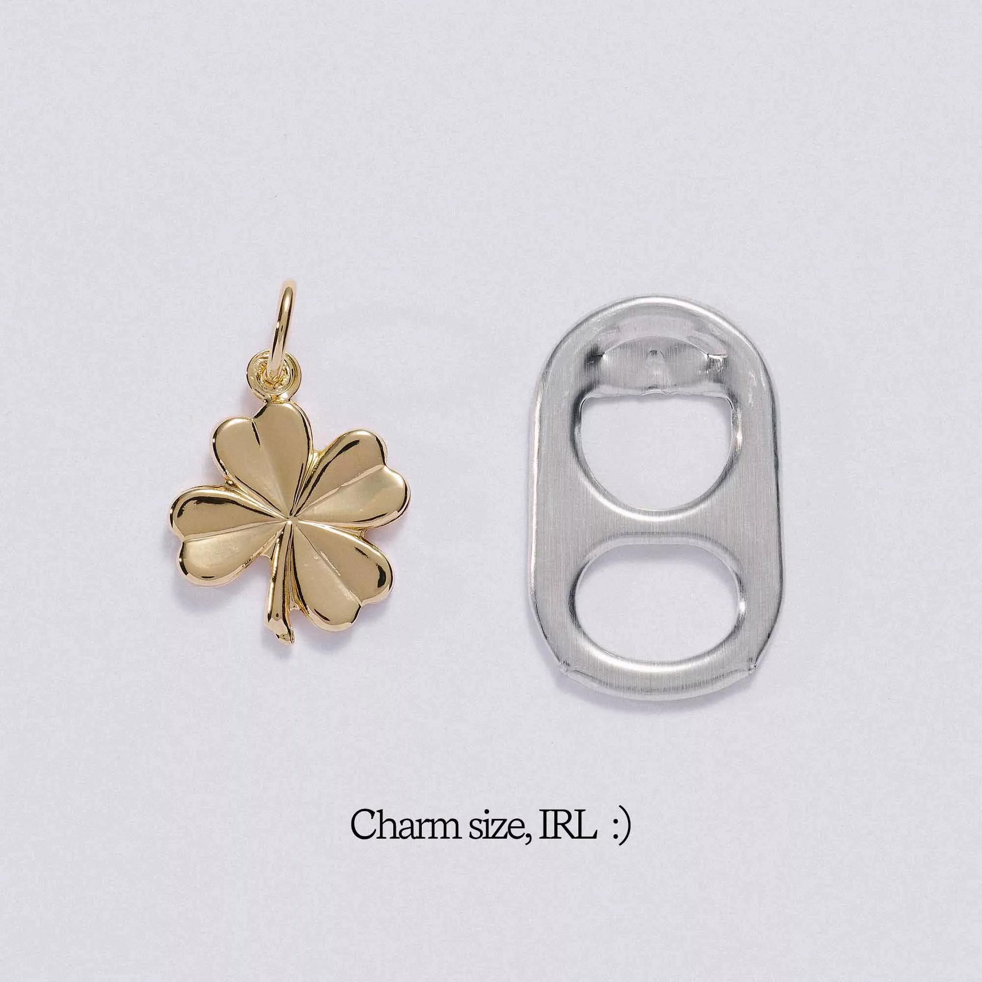 &LIVY Lucky Clover Charm in finely finished gold shown next to soda tab for size comparison with text Charm size IRL