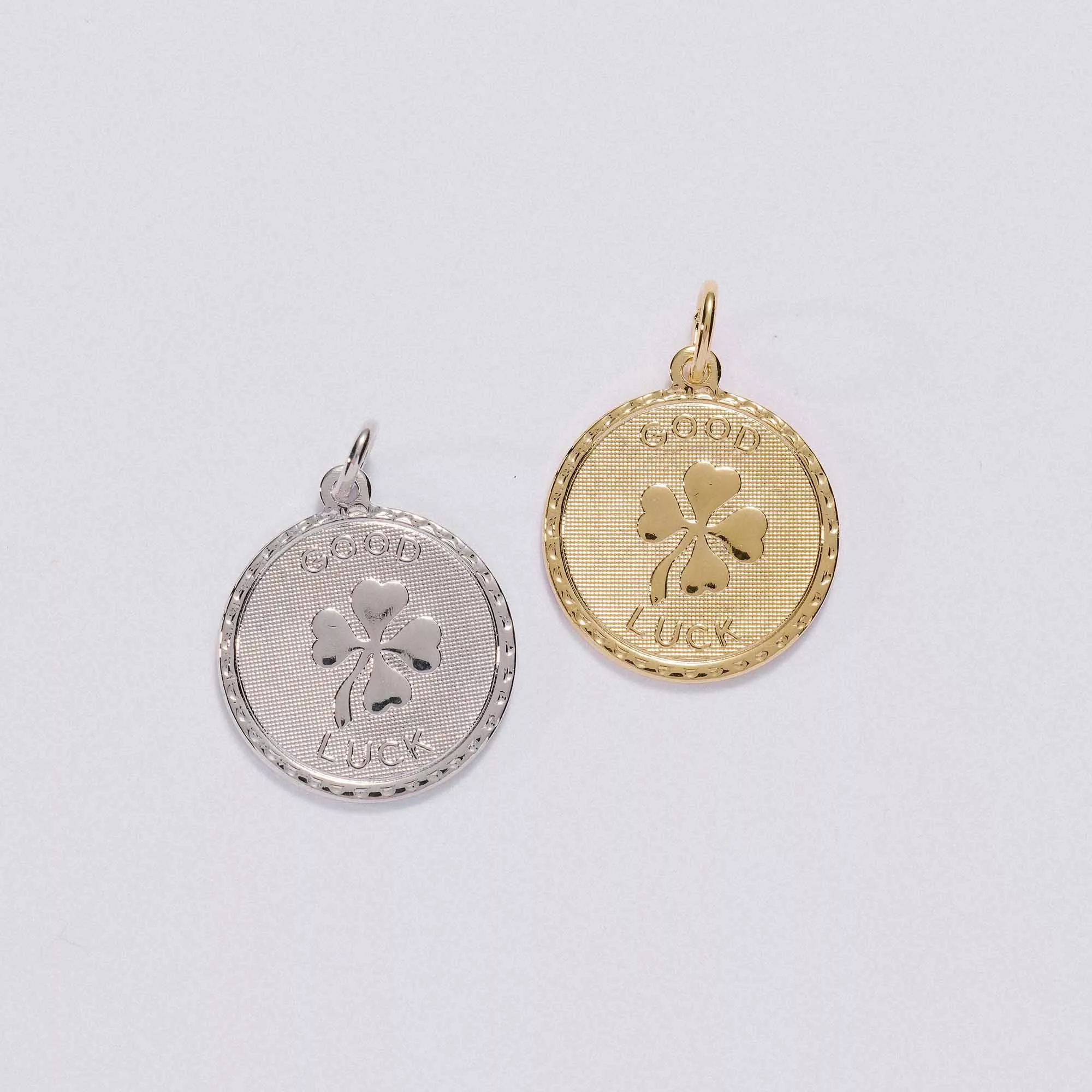 &LIVY Good Luck Token Charm in both silver and gold round coin pendants featuring four-leaf clover and Good Luck engraving with scalloped edge