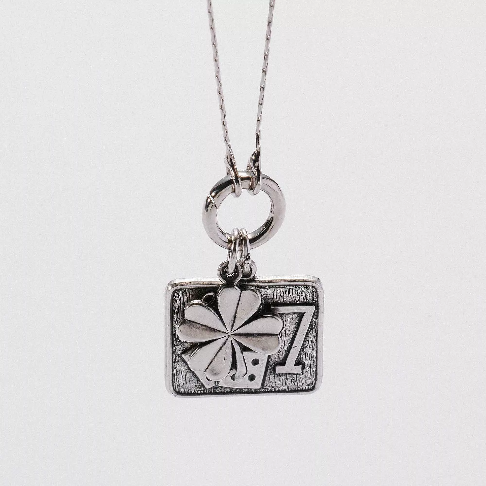 &LIVY Take a Chance Expandable Necklace silver close-up detail of Lucky 7 charm featuring four-leaf clover and dice engraving on expandable chain