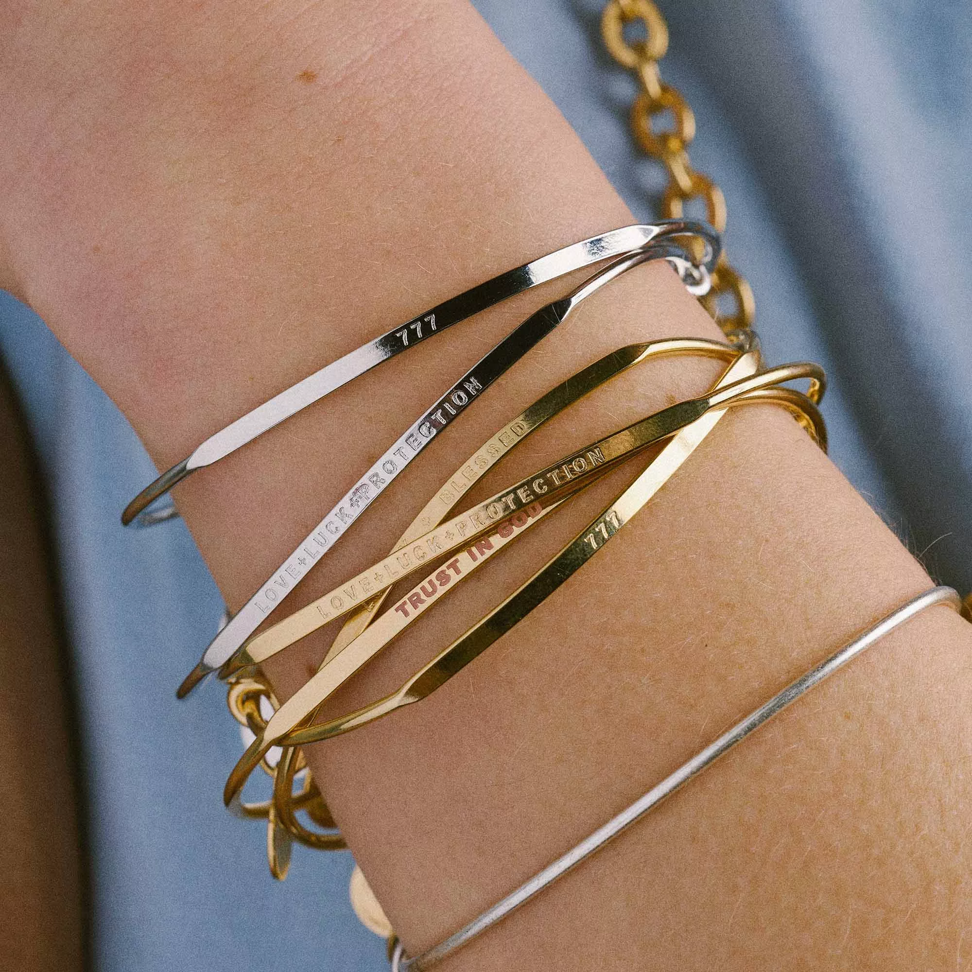 &LIVY Posy expandable bangle stack worn on wrist featuring gold and silver engraved bangles with inspirational messages