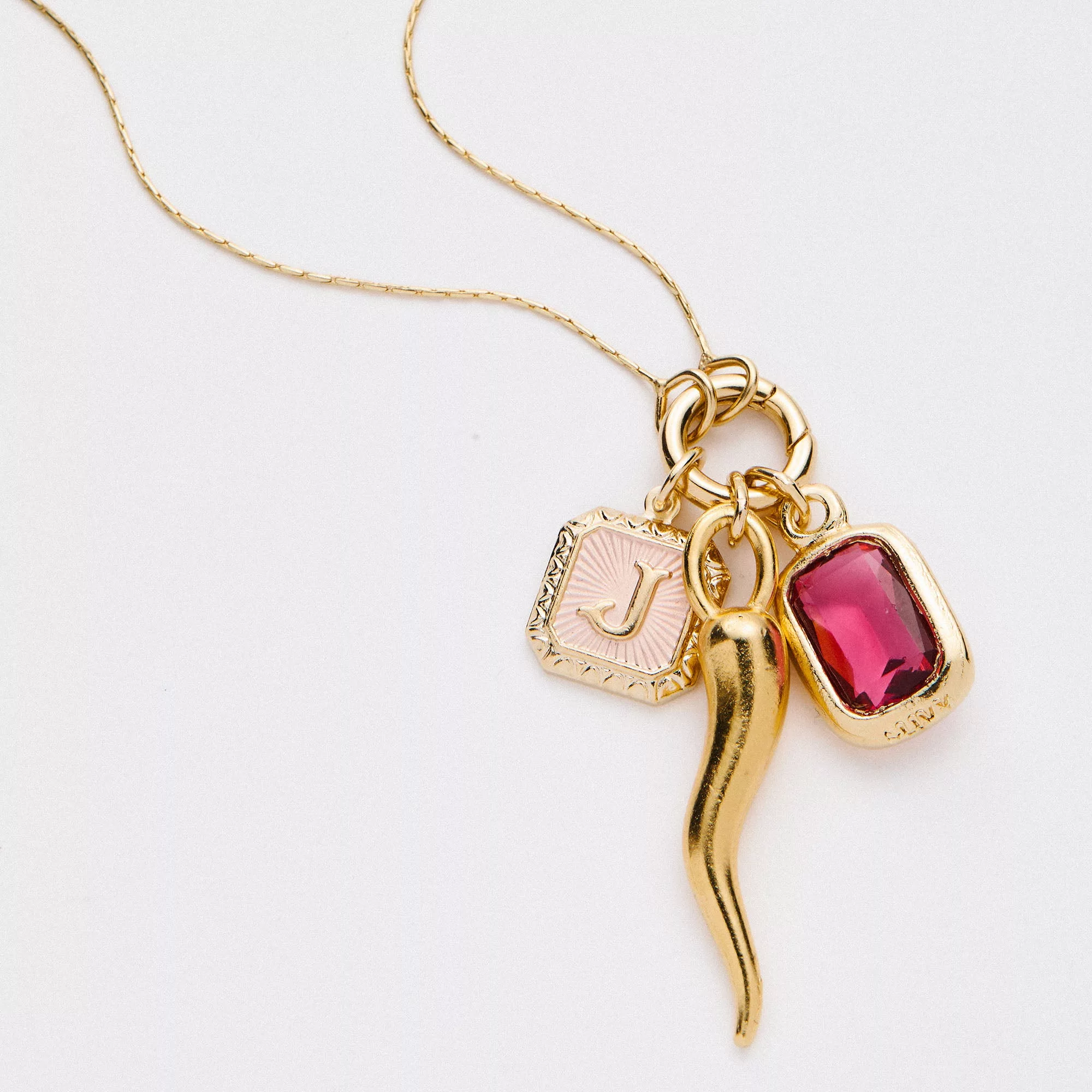 &LIVY Expandable Intention Chain Charm Necklace in finely finished gold featuring three charms gold Italian horn pink enamel letter charm and red crystal gemstone pendant on delicate gold chain