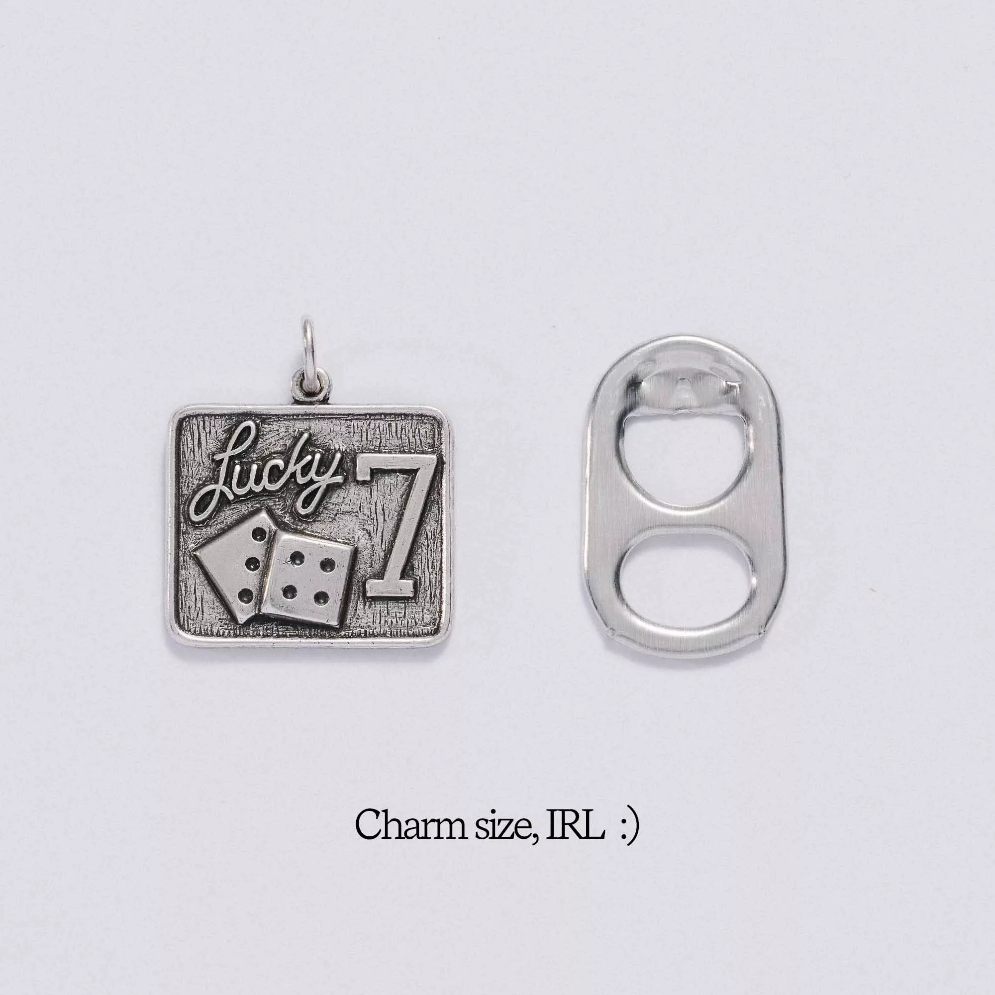 &LIVY Lucky 7 Charm in antique silver shown next to soda tab for size comparison with text Charm size IRL