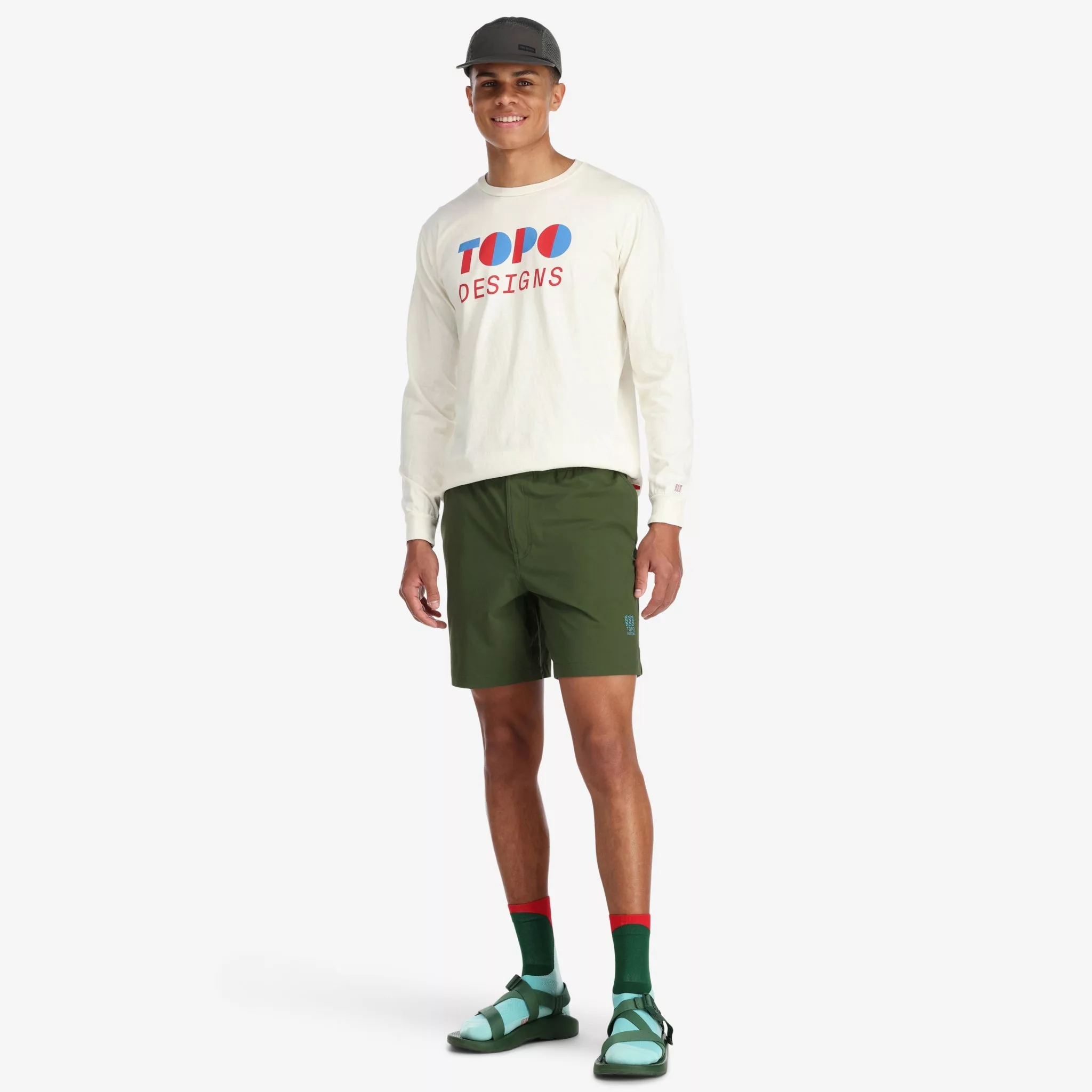Model wearing Topo Designs Men's Global lightweight quick dry travel Shorts in Olive green.